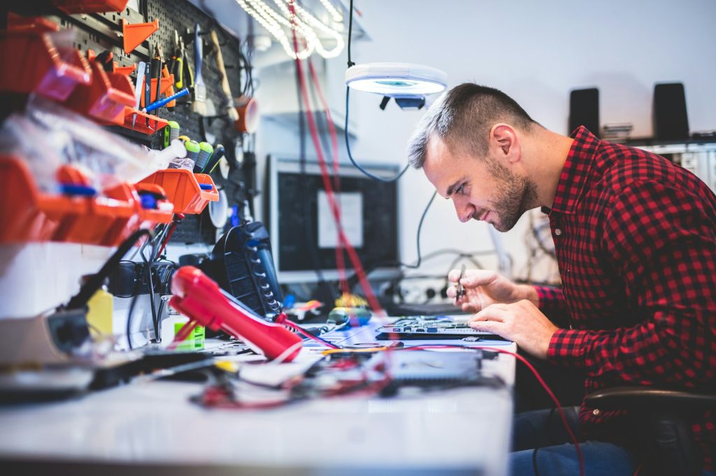 Man repairing laptop at workplace Man repairing laptop at workplace